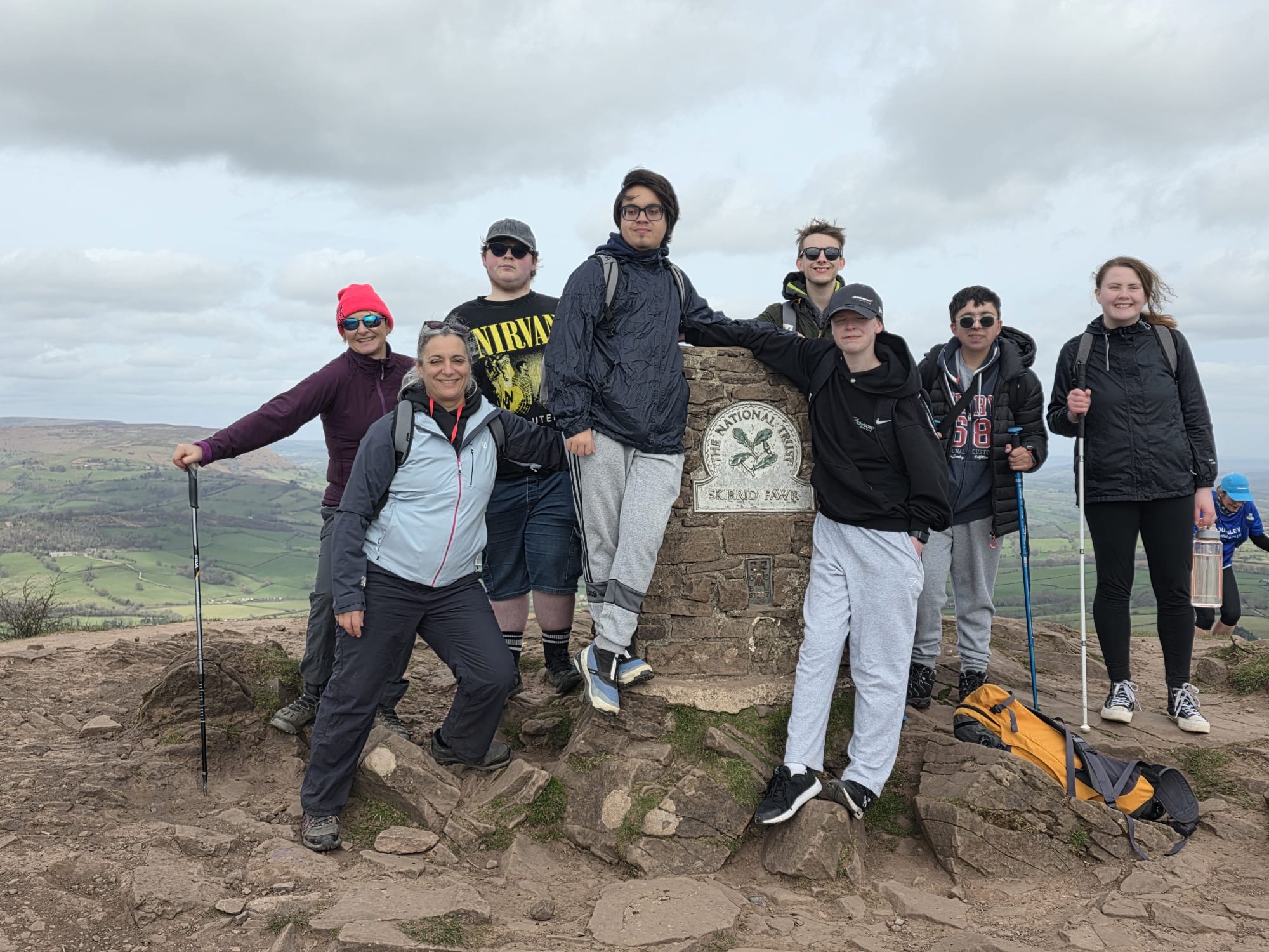 stand around the summit marker at the top of the Skirrid
