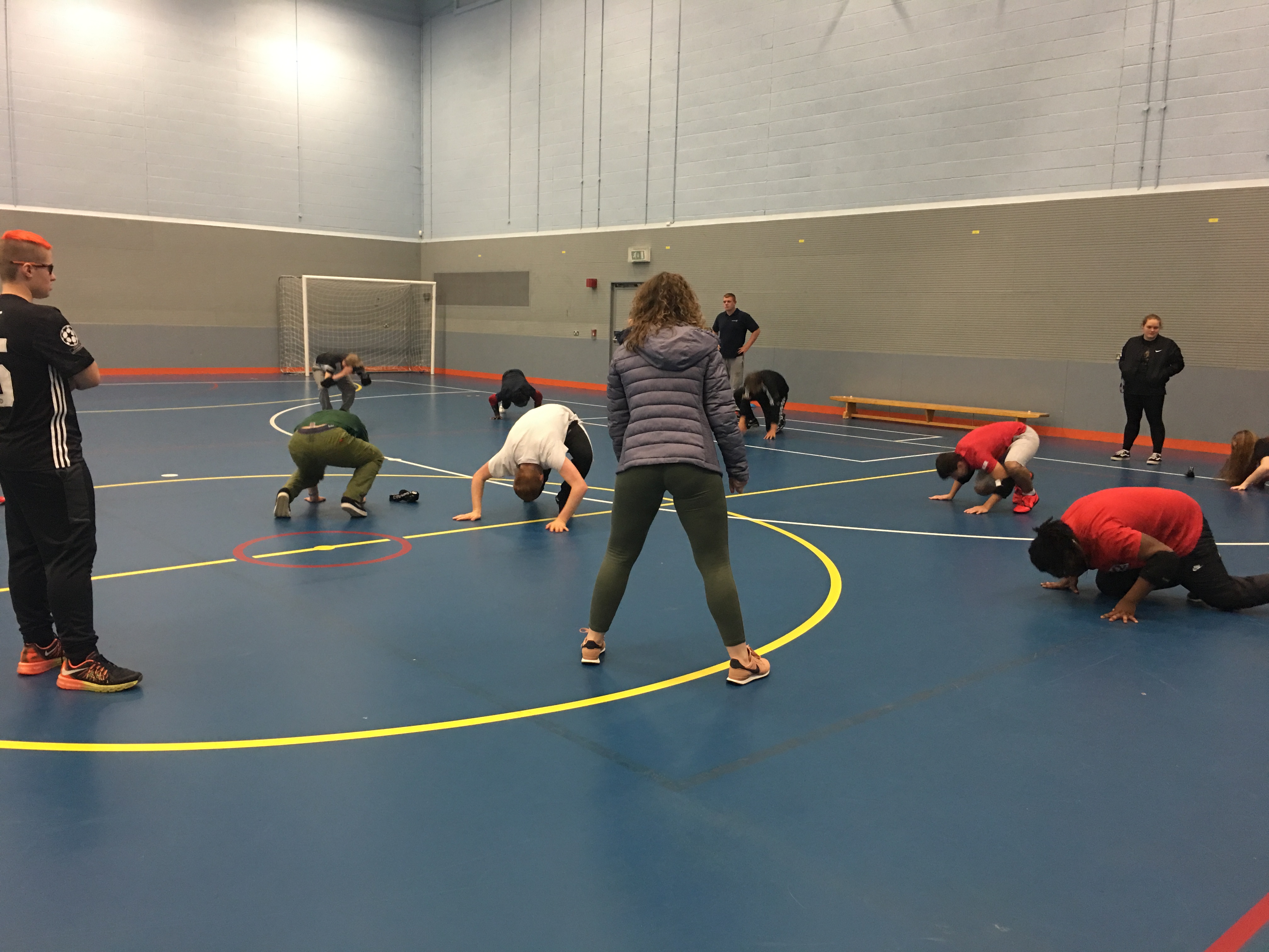 a female student leads a fitness class in the sports hall